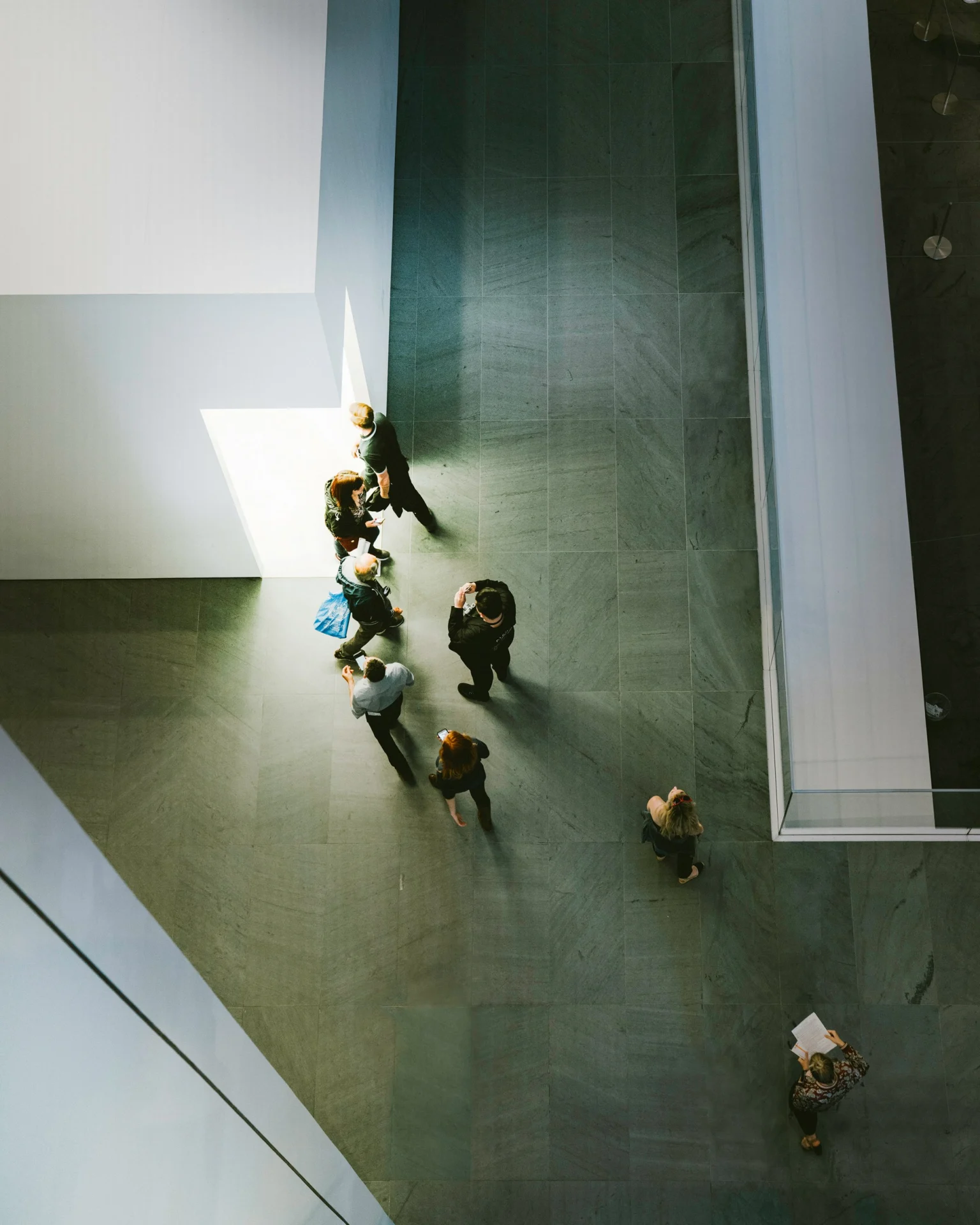 Bezoekers in een museumzaal, van bovenaf gezien